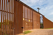 Gate along USA-Mexico border wall through Southmost Preserve. The border wall separates 85% of the reserve from the United State&#39;s side of the barrier. Nature Conservancy Reserve, Brownsville, Tex...