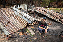 Joseph Henderson, one of the founders and managers of Wallabia Wildlife Shelter, in front of the burnt remains of his house, which was destroyed (along with the animal enclosures) during the 2019/20 b...