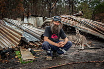 Joseph Henderson, one of the founders and managers of Wallabia Wildlife Shelter, in front of the burnt remains of his house, which was destroyed (along with the animal enclosures) during the 2019/20 b...