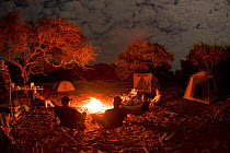 Expedition team around campfire at Running Creek, Cape York Peninsula, Queensland, Australia. August 2012