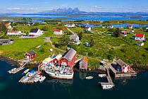 Aerial view of an island far out in the sea in Norway&#39;s widest strandflat. Fishing village with boats and boat houses. Brasoya, Helgeland Archipelago, Norway. July.
