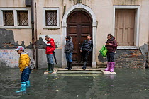 People waiting outside hose during flooding in Venice, Italy, December 2019.