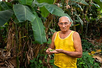 Farmer in Maisi, showing Cuban tree snails (Polymita picta) he protects in his garden. Cuba, March 2019