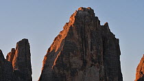 View of the Tre Cime di Lavaredo / Drei Zinnen (2,999m), three distinctive mountain peaks in the Sexten Dolomites at sunrise, South Tyrol, Italy, October 2019.