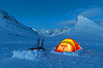 Photographers camping in the Jotunheimen mountains. Mt Kyrkja in the background. Norway. April 2020.