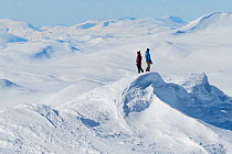 Photographers in snow-covered mountain landscape. Orsolya Haarberg and Erlend Haarberg. Vaga, Norway. March 2020.