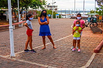 Family outing in deserted main street and park, During Covid-19 lockdown,normally crowded with tourists and locals, Puerto Ayora, Santa Cruz Island, Galapagos Islands