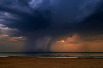 Thunderstorm with dark rain clouds and cloudburst / deluge over the sea during heatwave in summer, Belgium, July