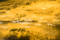 Aerial view of a golden and foggy sunrise over a bog area, Alam-Pedja National Park, Tatrumaa county, Southern Estonia. May.