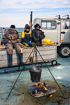 Fishermen cooking food on the Barguzin river. Lake Baikal, Siberia, Russia. April 2016.