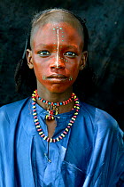 Boy from Wodaabe nomadic tribe with painted face, portrait. During Gerewol celebration, a gathering of different clans in which women choose a husband. Chad, Sahel, Africa. 2019.