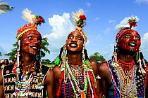 Three men from Wodaabe nomadic tribe celebrating Gerewol, a gathering of different clans in which women choose a husband. Men dress in best clothes and ornaments to sing and dance in front of the youn...