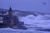 Porthleven clocktower and harbour at sunrise and high-tide during Storm Ciara, Cornwall, UK. February 2020.