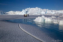 Scientists travelling on the fast ice to a fishing location at a tide crack, Dumont d&#39;Urville station, Antarctica, December 2016