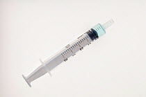 A veterinary syringe with a small amount of liquid on a white background.