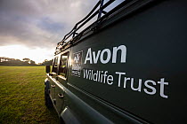 An Avon Wildlife Trust Land Rover on farmland at dawn during a programme to vaccinate European badgers (Meles meles) against TB in North Somerset, UK. Badger vaccination programmes are being carried o...