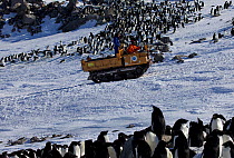 Tracked vehicle returning to Dumont d&#39;Urville station past penguin colony, Antarctica, 2013.