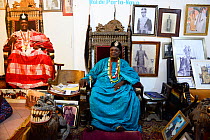 King of Porto Novo, Toffa IX sitting on throne chair in the palace courtroom, surrounded by photographs, Benin, 2020.