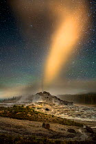 Castle Geyser erupting under a night sky in the Upper Geyser Basin of Yellowstone National Park, Wyoming, USA. July.