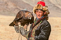 Eagle hunter with female golden eagle (Aquila chrysaetos) at the Eagle Hunters festival near Ulgii Western Mongolia.