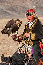 Eagle hunter with female golden eagle (Aquila chrysaetos) at the Eagle Hunters festival near Ulgii Western Mongolia.