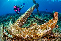 Diver exploring the wreckage of the wreck of the Glamis finding a large anchor, East End, Grand Cayman, Cayman Islands, British West Indies. Caribbean Sea.