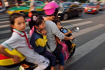 Woman and three children on a scooter/motorbike, Xia Shan area in the Zhan Jiang city, Guangdong, China, November 2015.