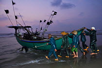 Fishermen launching their boats at dawn on Nan San island, Guangdong province, China, November 2015 Editorial use only.