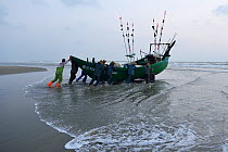 Fishermen launching their boats at dawn on Nan San island, Guangdong province, China, November 2015