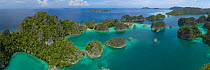 Fam Islands, karst limestone islands covered with rainforest in Pacific Ocean, aerial view. Raja Ampat Islands, Indonesia. 2018.
