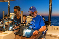 Scientists Dr. Dexter de la Cruz and Prof. Peter Harrison from Southern Cross University looking down microscopes at Coral larvae. Part of Coral IVF project to rear coral and replenish degraded sectio...