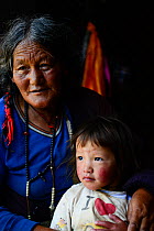 Portrait of woman and child, Tibetan Buddhist pilgrims at Ganden Thubchen Choekhorling Monastery. Litang, Garze Tibetan Autonomous Prefecture, Sichuan, China. 2016.