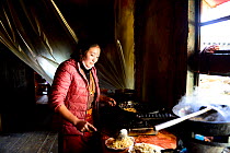 Woman cooking in kitchen of Palpung Monastery. Kham, Dege County, Garze Tibetan Autonomous Prefecture, Sichuan, China. 2016.