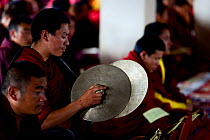 Buddhist monk playing cymbals during mass. Palpung Monastery, Kham, Dege County, Garze Tibetan Autonomous Prefecture, Sichuan, China. 2016.