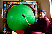 Monk beating gong during Buddhist mass. Palpung Monastery, Kham, Dege County, Garze Tibetan Autonomous Prefecture, Sichuan, China. 2016.