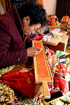 Craftsman creating wooden plate for printing Buddhist prayers. Palpung Monastery, Kham, Dege County, Garze Tibetan Autonomous Prefecture, Sichuan, China. 2016.