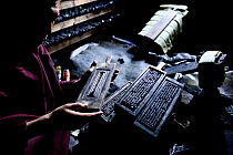 Monk with wooden plates used to print Buddhist prayers and texts. Palpung Monastery, Kham, Dege County, Garze Tibetan Autonomous Prefecture, Sichuan, China. 2016.