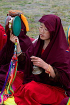 Buddhist nun ringing bell. Gyerco Monastery, Tagong, Garze Tibetan Autonomous Prefecture, Sichuan, China. 2016.