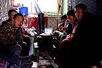 Group of novice monks sitting around stove whilst resting at Bangpu Monastery / Panphuk Gompa, Sangdui, Sichuan, China. 2016.