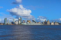 HMS Prince of Wales aircraft carrier moored at the Liverpool Pierhead on the River Mersey with the Three Graces building on the right, Liverpool, England, UK, March 2020.