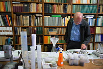 Entomologist with sample of Insects caught in malaise trap, reference books in background. Long-term monitoring has revealed a 75% decline in insect biomass over 27 years. Entomological Society Krefel...