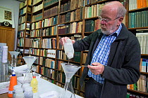 Entomologist draining Insect sample prior to weighing, reference books in background. Long-term monitoring has revealed a 75% decline in insect biomass over 27 years. Entomological Society Krefeld, Ge...