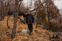 Photographer Sergey Gorshkov setting up remote camera traps to photograph Siberian tiger in Land of the Leopard National Park, Far East Russia. 2019