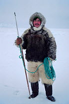 Ituko, an Inuit hunter, dressed in fox parka and polar bear fur trousers, holding a harpoon. N.W. Greenland. 1980.