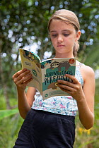 Local student reading Sloth conservation booklet during Sloth Conservation Foundation community education session. Puerto Viejo de Talamanca, Costa Rica. 2010.