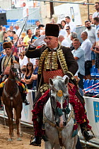 Man on horseback saluting during Alka procession, spectators in background. Held on the first Sunday in August since 1715 the Alka commemorates the victory of Christians over Ottoman Turks. Inscribed...