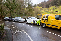 Breakdown vehicle picking up cars broken down in floodwaters of Storm Ciara. Rothay Bridge, Ambleside, Lake District, England, UK. February 2020.