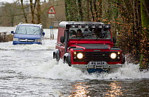 Land Rover driving through flood caused by Storm Ciara. Rothay Bridge, Ambleside, Lake District, UK. February 2020.