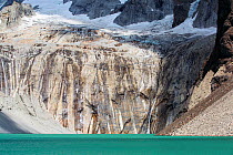 Meltwater from retreating glacier flowing over rock into lake, below Torres del Paine towers. Torres del Paine National Park, Patagonia, Chile. January 2020.