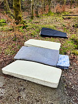 Mattreses fly tipped and illegally dumped in car park. White Moss, near Ambleside, Lake District National Park, England, UK. February 2020.